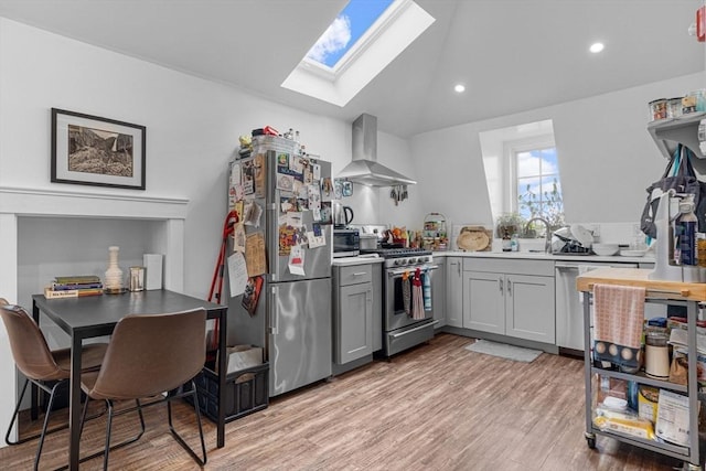 103-105 Broadway, Chelsea, MA 02150 - kitchen featuring appliances with stainless steel finishes, wall chimney exhaust hood, gray cabinetry, a skylight, and a sink