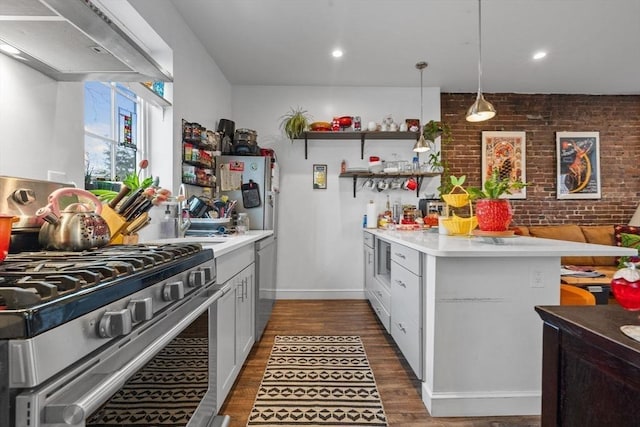 103-105 Broadway, Chelsea, MA 02150 - kitchen with stainless steel appliances, dark wood-style floors, a peninsula, light countertops, and brick wall