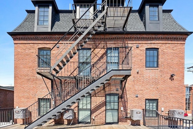 103-105 Broadway, Chelsea, MA 02150 - view of home's exterior featuring brick siding, roof with shingles, stairs, and a balcony
