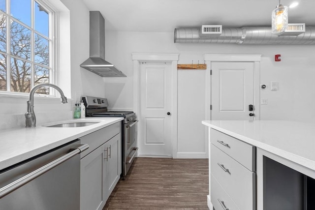103-105 Broadway, Chelsea, MA 02150 - kitchen featuring stainless steel appliances, wall chimney range hood, a sink, dark wood-style flooring, and light countertops