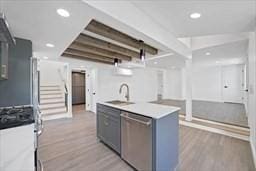 kitchen featuring stainless steel appliances, sink, hardwood / wood-style floors, and gray cabinetry