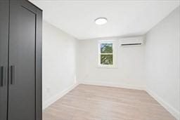 interior space with an AC wall unit and light wood-type flooring