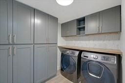 laundry room with washer and dryer and cabinets