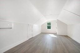 bonus room featuring lofted ceiling and dark hardwood / wood-style floors