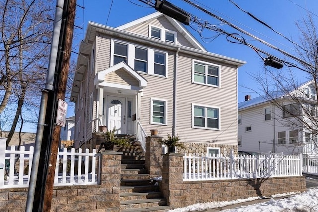 american foursquare style home featuring a fenced front yard