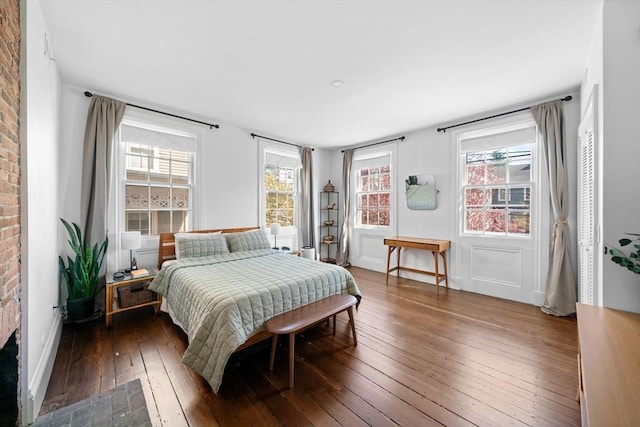 bedroom featuring baseboards, multiple windows, and hardwood / wood-style floors