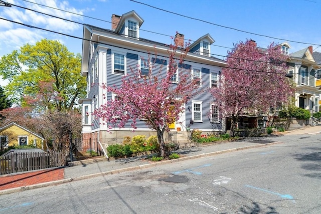 view of property with fence and a chimney