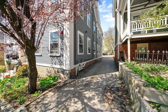 view of property exterior featuring aphalt driveway and a balcony
