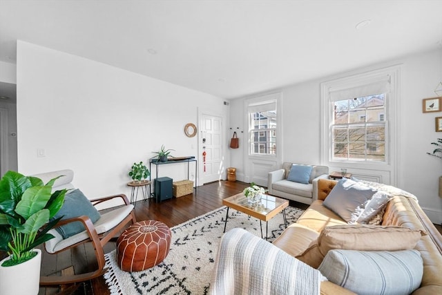living area with baseboards and wood finished floors