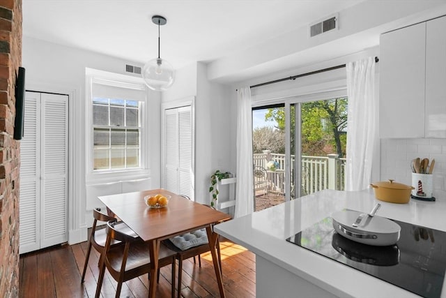 dining area featuring visible vents and dark wood-style floors