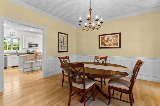 8 Mill River Ln, Rowley, MA 01969 - dining space with a chandelier, light wood-style flooring, wainscoting, and ornamental molding