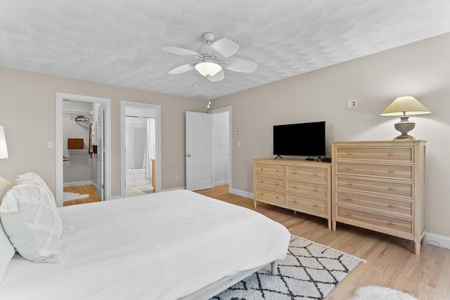 8 Mill River Ln, Rowley, MA 01969 - bedroom featuring light wood-type flooring, a walk in closet, a closet, ceiling fan, and connected bathroom