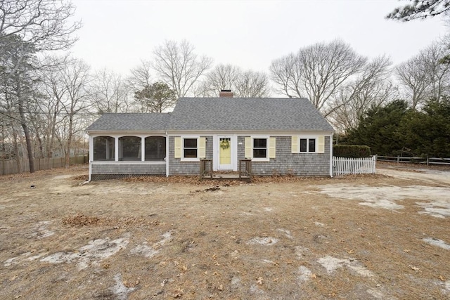 single story home featuring roof with shingles, a chimney, and fence