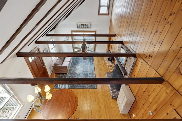 staircase featuring vaulted ceiling with beams, wood walls, and wood finished floors