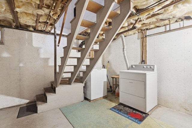 unfinished basement with stairs, separate washer and dryer, and fridge