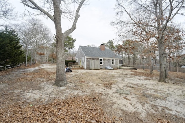 exterior space with a deck, a chimney, and fence