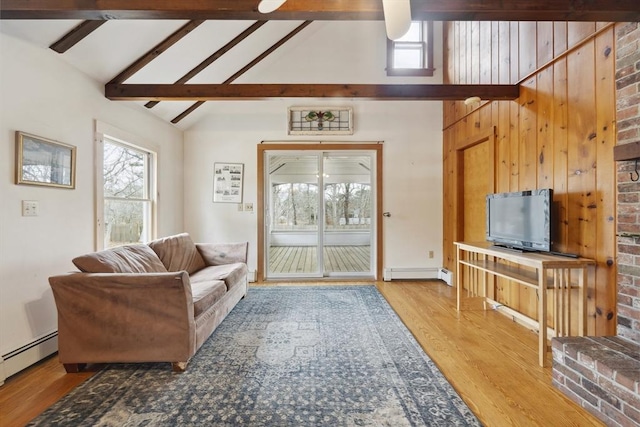 living room featuring vaulted ceiling with beams, a baseboard radiator, and wood finished floors