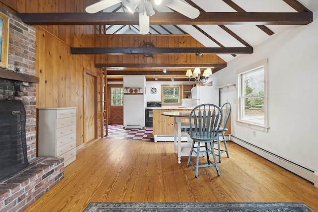 kitchen featuring a baseboard heating unit, light wood-type flooring, lofted ceiling with beams, and a brick fireplace