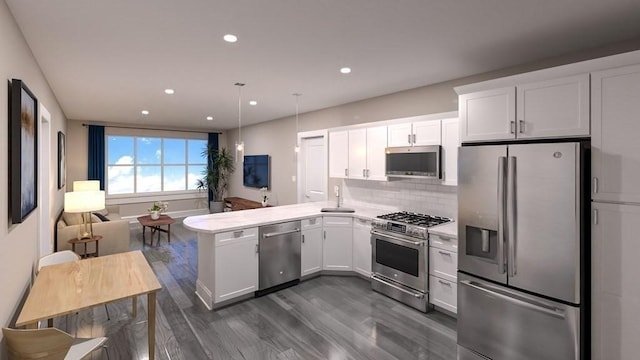 21 Totman St Unit Model-1, Quincy, MA 02169 - kitchen featuring appliances with stainless steel finishes, a peninsula, dark wood-style flooring, light countertops, and white cabinetry