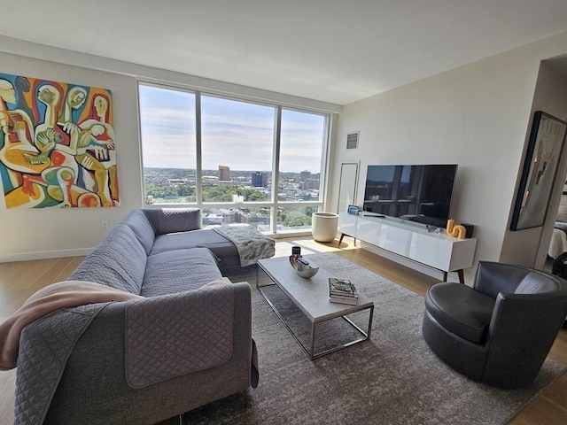 living room featuring wood-type flooring and floor to ceiling windows