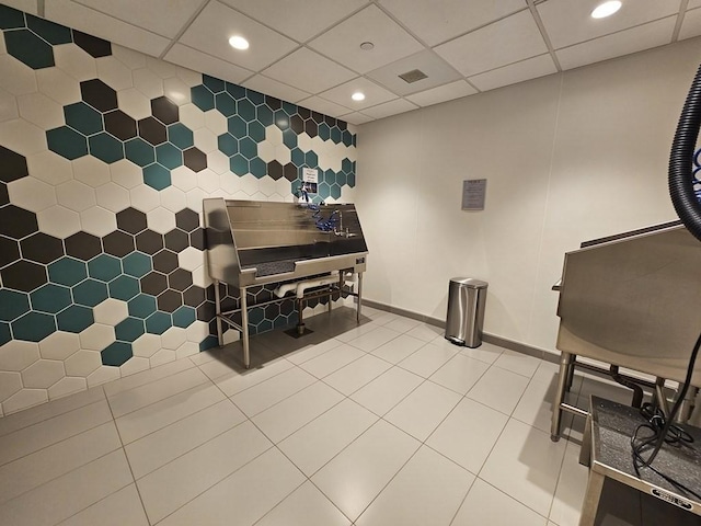 misc room featuring a drop ceiling, tile walls, and tile patterned flooring