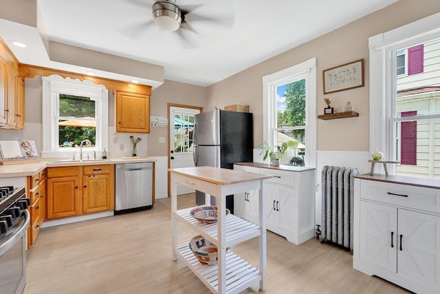 50 Oleander St, West Springfield, MA 01089 - kitchen featuring radiator heating unit, appliances with stainless steel finishes, a ceiling fan, plenty of natural light, and wainscoting