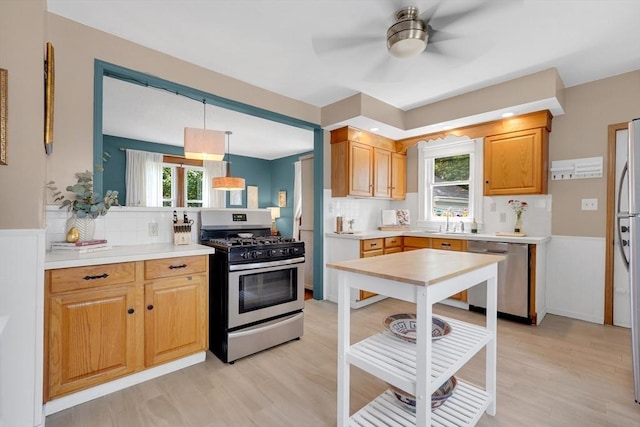 50 Oleander St, West Springfield, MA 01089 - kitchen with appliances with stainless steel finishes, plenty of natural light, light wood finished floors, a ceiling fan, and wainscoting