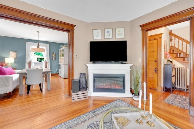 50 Oleander St, West Springfield, MA 01089 - living room with radiator, stairway, light wood finished floors, and a glass covered fireplace