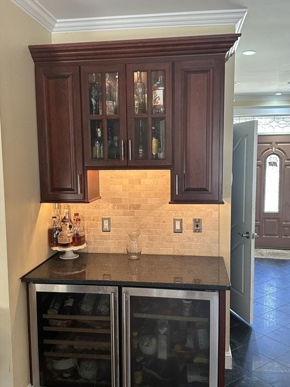 bar featuring wine cooler, a bar, crown molding, and tasteful backsplash