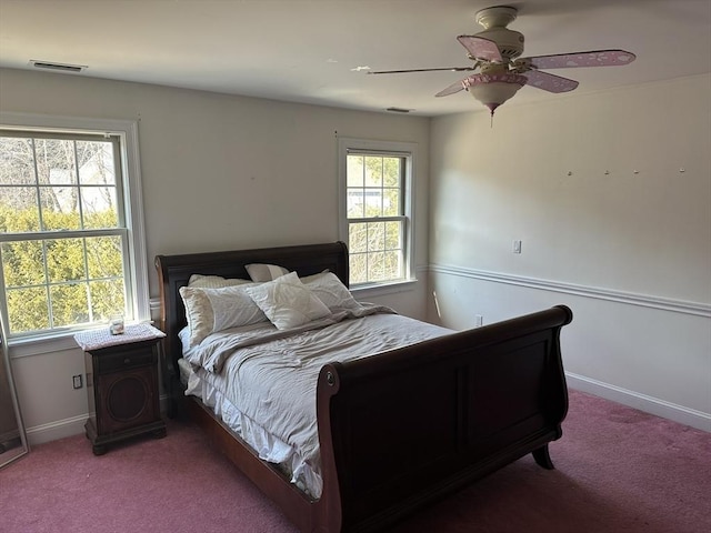 carpeted bedroom featuring a ceiling fan, visible vents, and baseboards