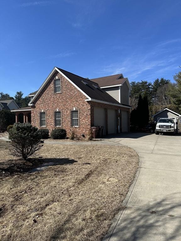 view of home's exterior featuring brick siding, an attached garage, and concrete driveway