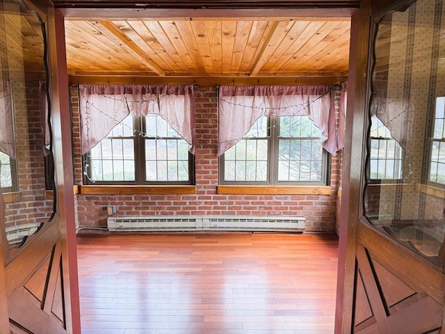 unfurnished room featuring wooden ceiling, a baseboard heating unit, and a healthy amount of sunlight