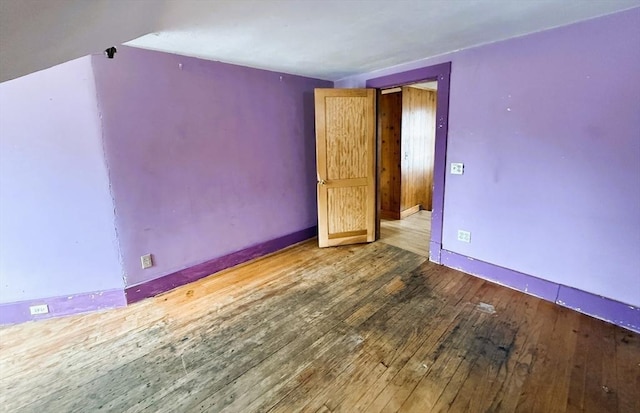 empty room featuring hardwood / wood-style flooring and baseboards