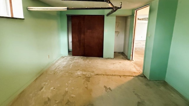 unfurnished bedroom with unfinished concrete flooring