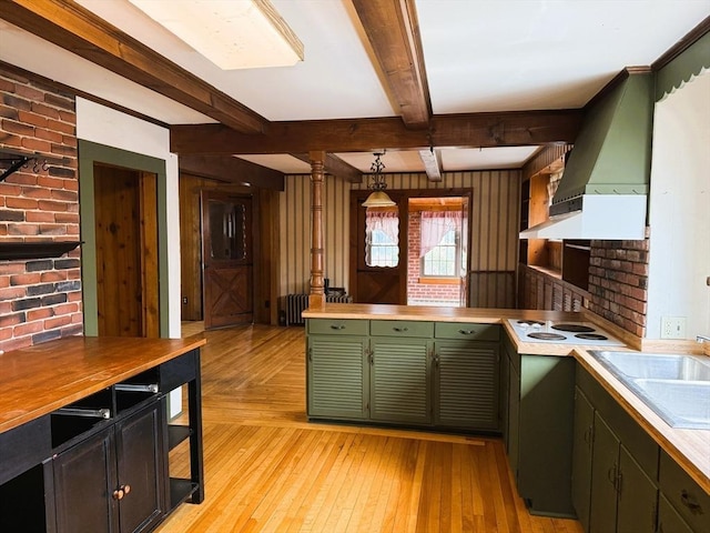 kitchen with custom exhaust hood, a sink, light wood-style floors, beamed ceiling, and green cabinets