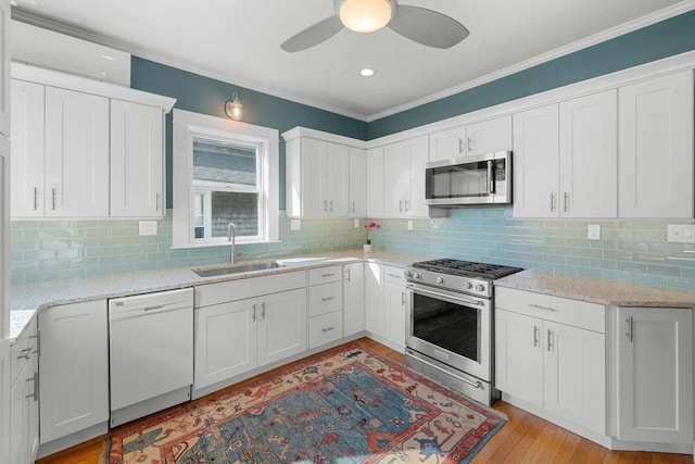2 Howland Ave, Dartmouth, MA 02748 - kitchen with stainless steel appliances, a sink, a ceiling fan, white cabinetry, and crown molding