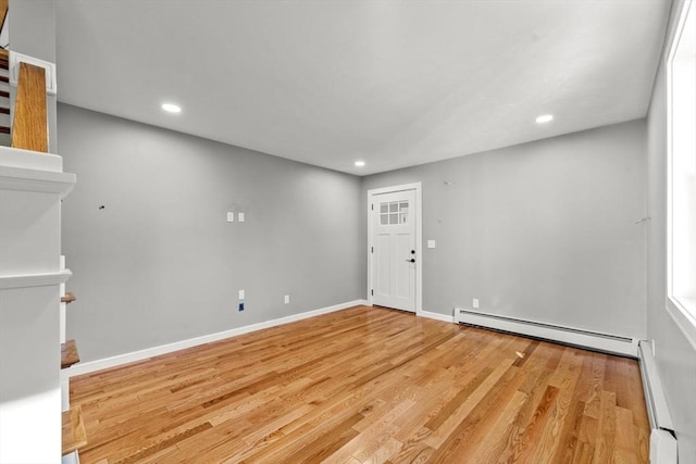 unfurnished room with light wood-type flooring and baseboard heating