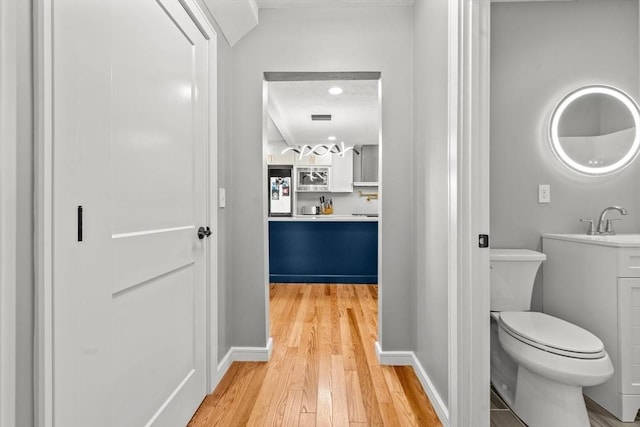 bathroom with vanity, wood-type flooring, and toilet