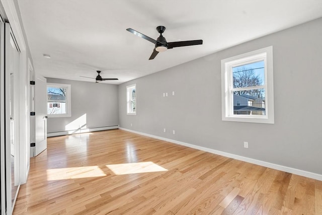 interior space with baseboard heating, light hardwood / wood-style flooring, and ceiling fan