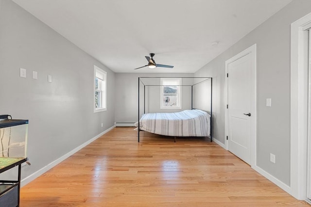 unfurnished bedroom with ceiling fan, light hardwood / wood-style floors, and a baseboard heating unit