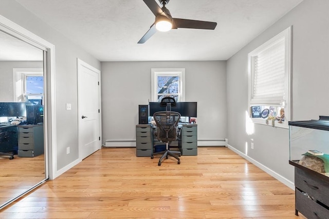 office area with baseboard heating, ceiling fan, and light hardwood / wood-style flooring