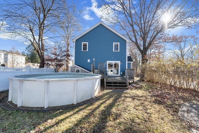 back of house with a lawn and a swimming pool side deck