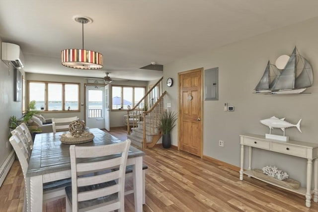 18 River St, Seabrook, NH 03874 - dining area with a wall unit AC, light wood-type flooring, stairs, and ceiling fan