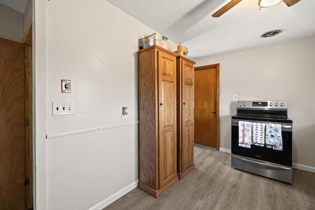 kitchen with light wood-type flooring, ceiling fan, and electric stove