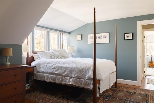 bedroom featuring dark wood-type flooring and vaulted ceiling