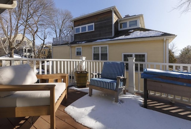 snow covered house with a wooden deck