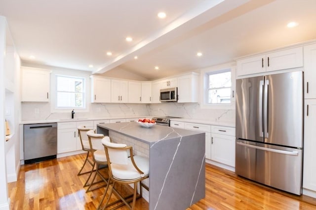 kitchen with appliances with stainless steel finishes, light wood-type flooring, and white cabinetry