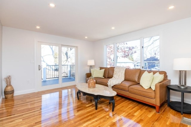 living room with baseboards, light wood finished floors, and recessed lighting