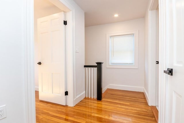 hall featuring light wood finished floors, recessed lighting, an upstairs landing, and baseboards