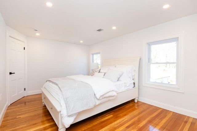 bedroom featuring recessed lighting, visible vents, light wood-style flooring, and baseboards